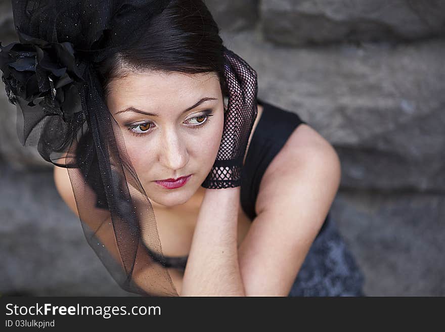 Retro-stylized woman in black hat with veil and black dress.