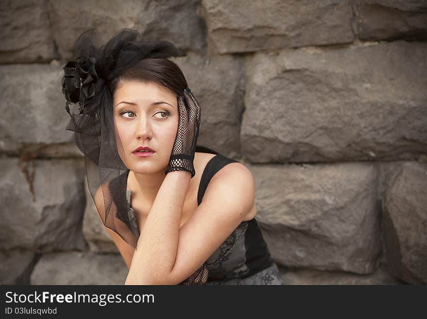 Retro-stylized woman in black hat with veil and black dress.