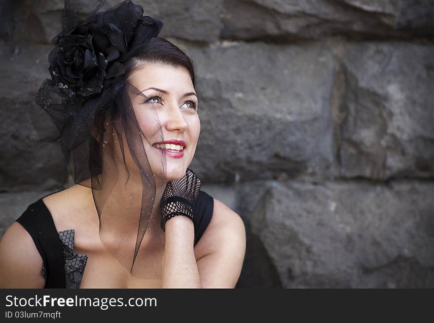 Retro-stylized woman in black hat with veil and black dress.