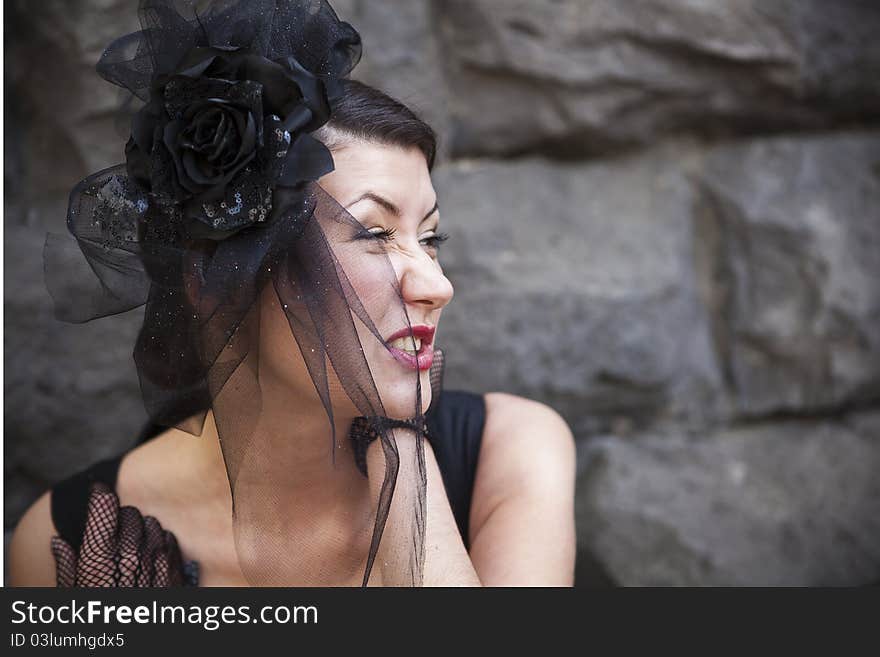 Retro-stylized woman in black hat with veil and black dress.