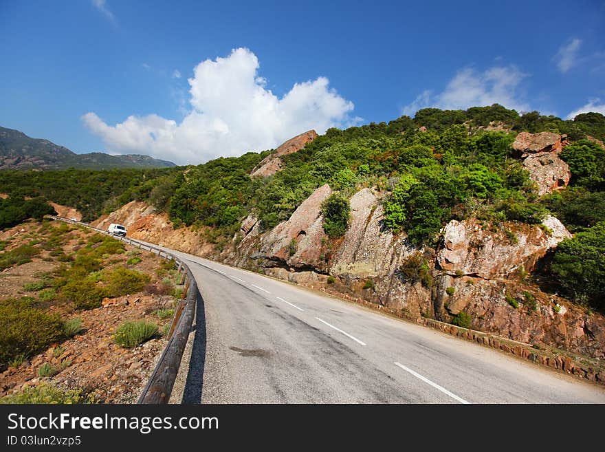 Rock cliff paved road in Corsica