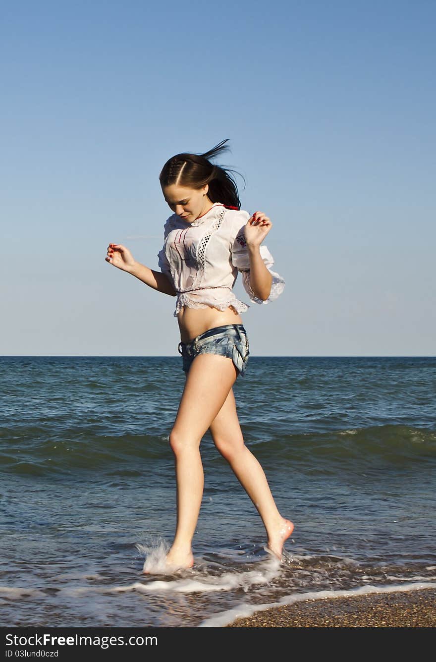 Beautiful woman in shorts running on the beach