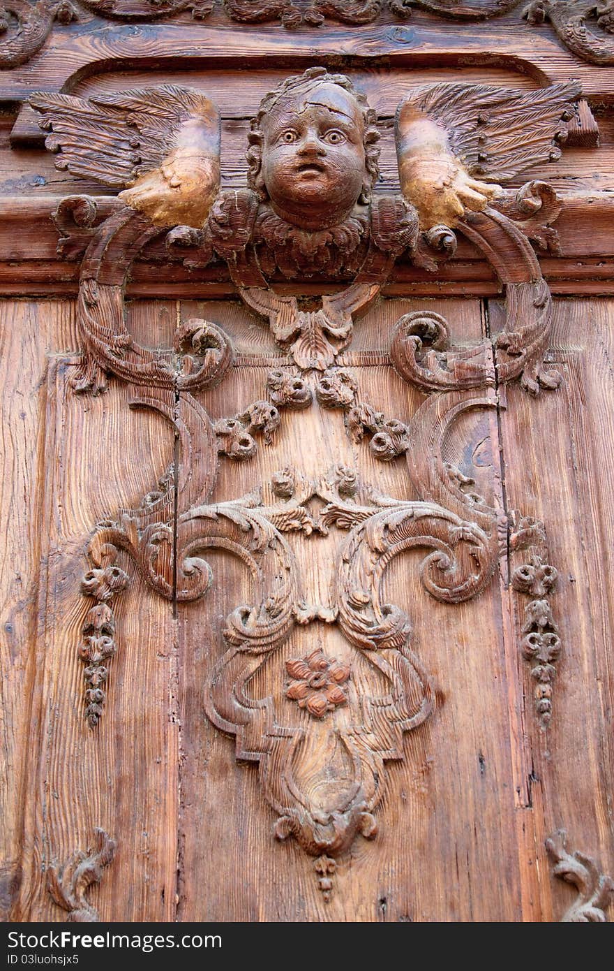 Old carved wooden door of the church Parroquia Castrense De La Ciudadela in Ciutadella Park , Barcelona, Spain