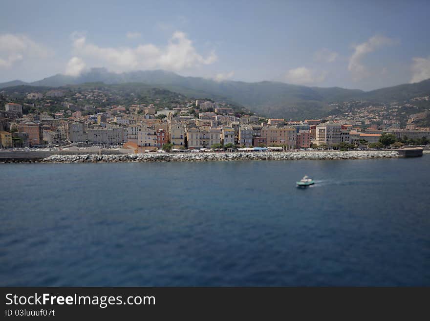 Coastal city with embankment and marina, with a boat