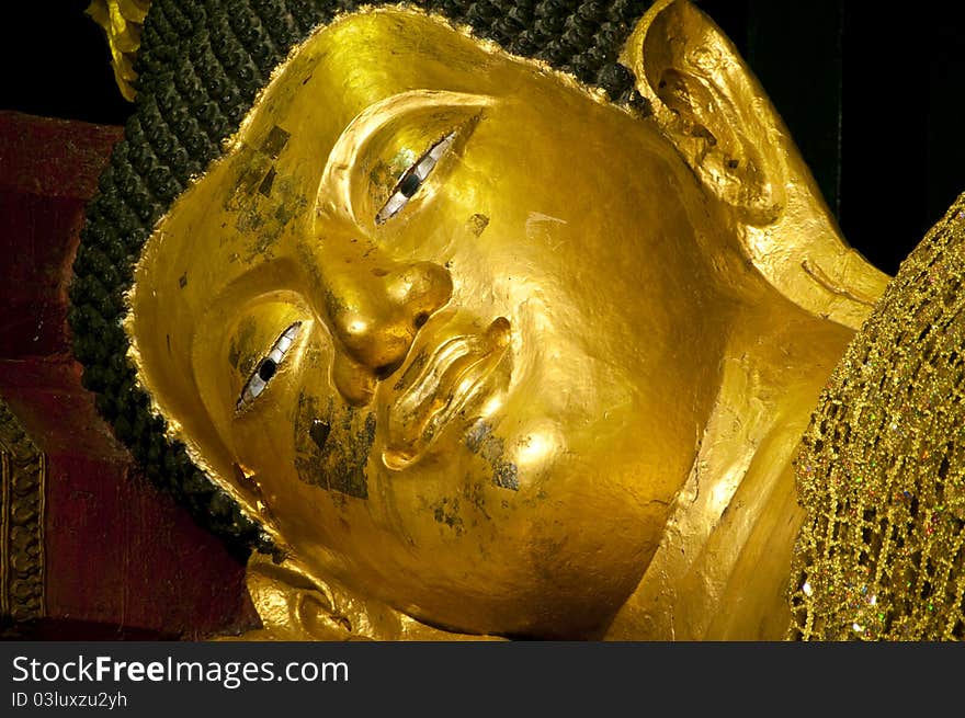 The face of golden buddha in sleeping posture, Chiangmai Thailand.