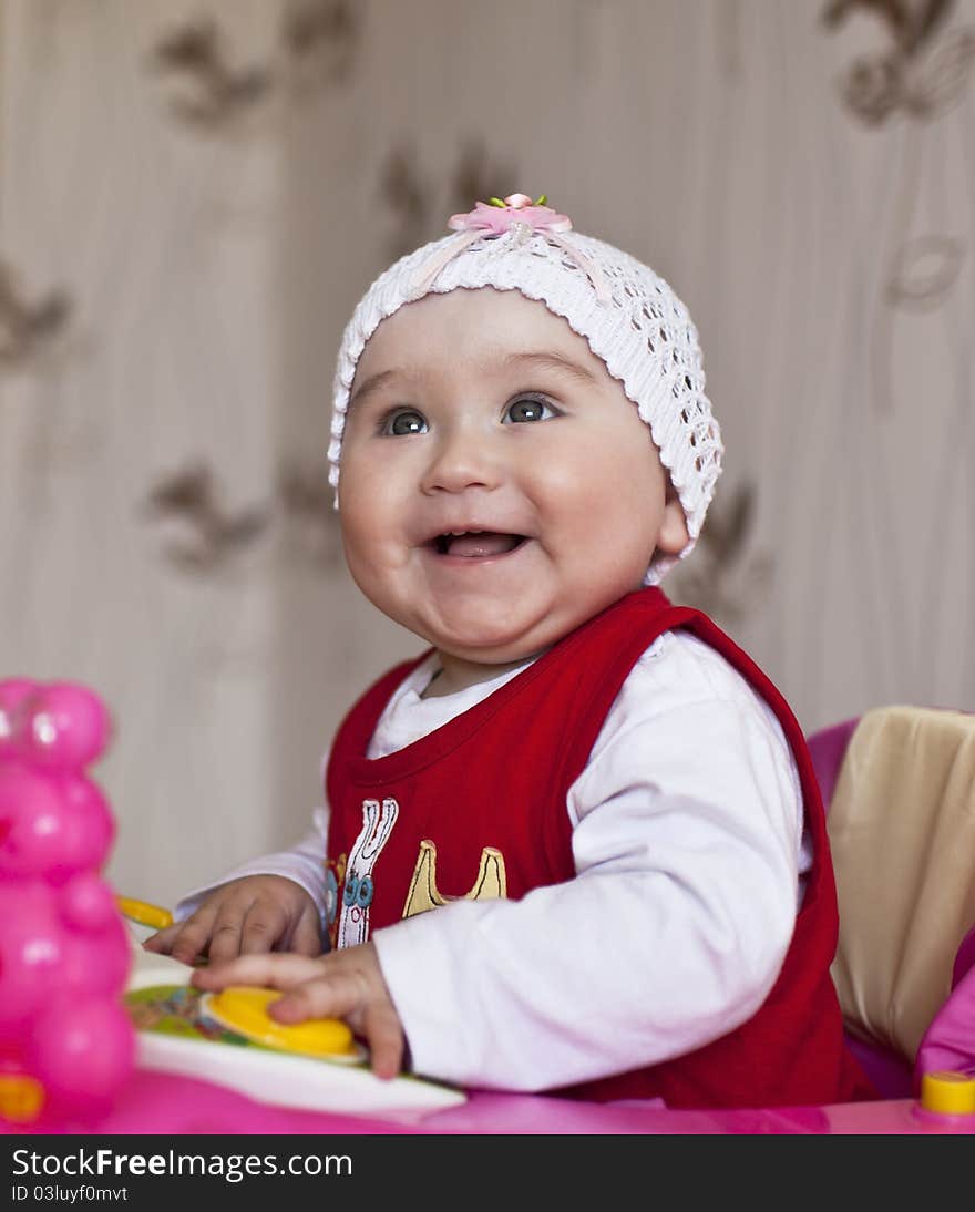 Beautiful little baby in pink dress at home