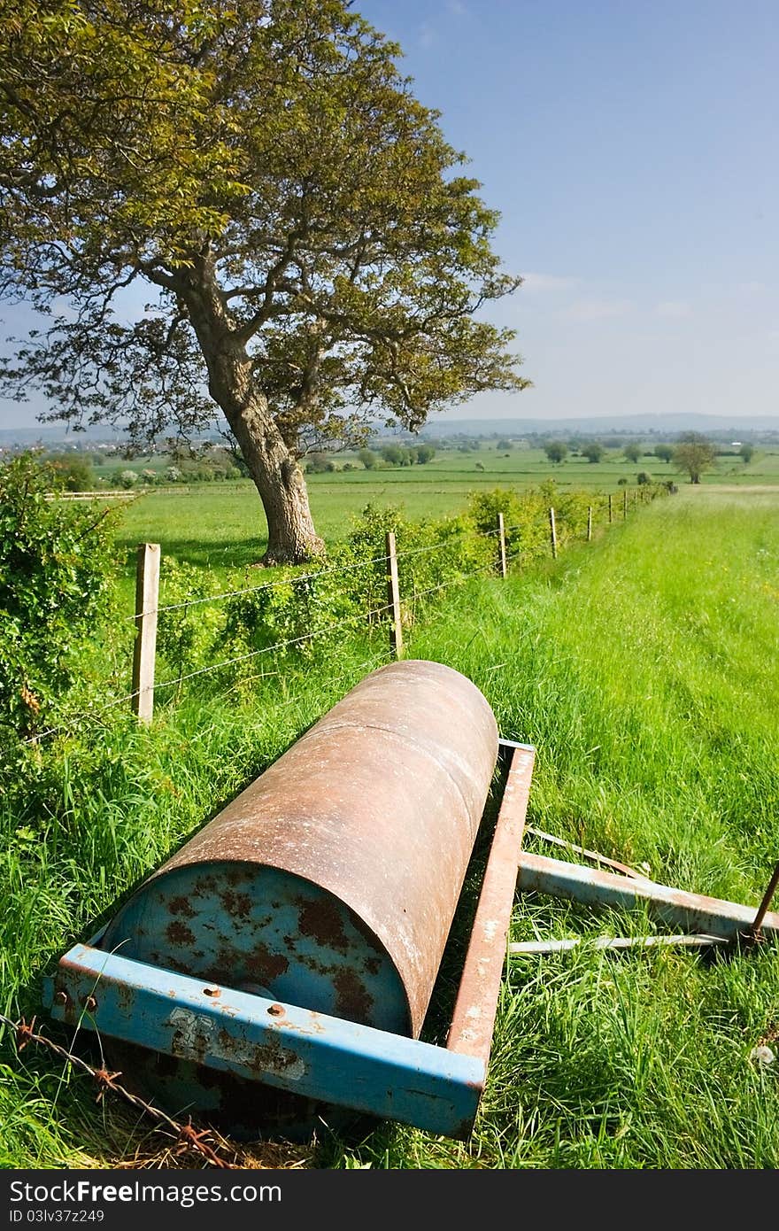 Rusty farm equipment in an english field in summer. Rusty farm equipment in an english field in summer