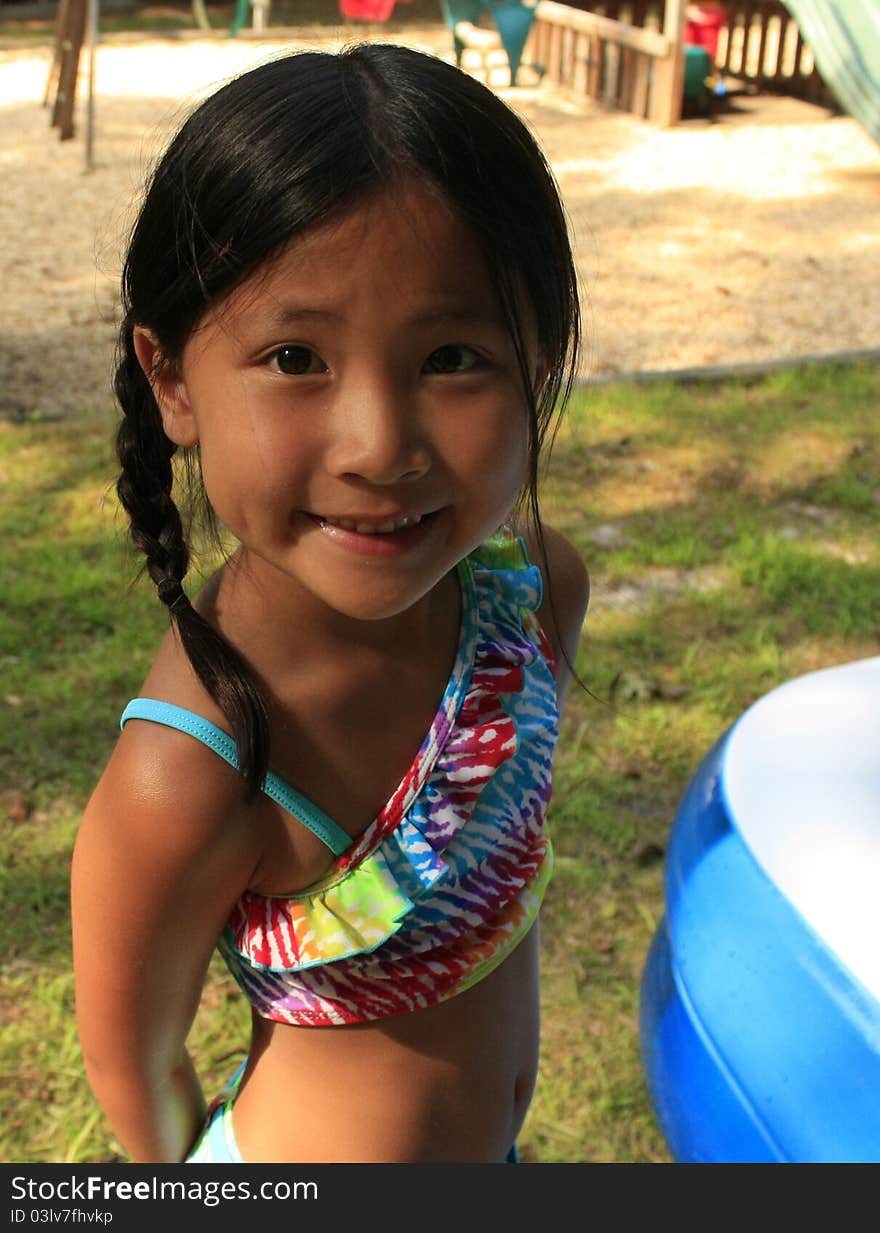 Little asian chinese girl with breads in a bathing suit. Little asian chinese girl with breads in a bathing suit