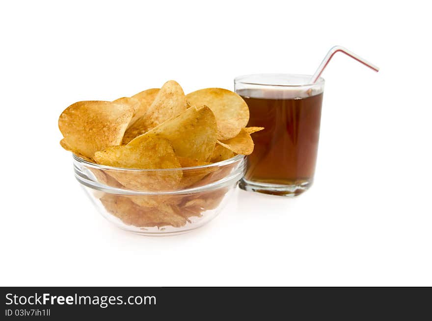 Chips in a dish on a background glass with drink on a white background