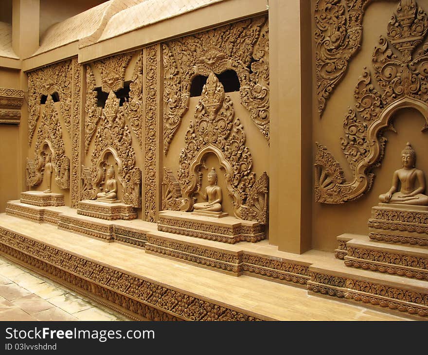 Row of sitting Budhha statues along the wall of a temple in Kanchanaburi, Thailand. Row of sitting Budhha statues along the wall of a temple in Kanchanaburi, Thailand