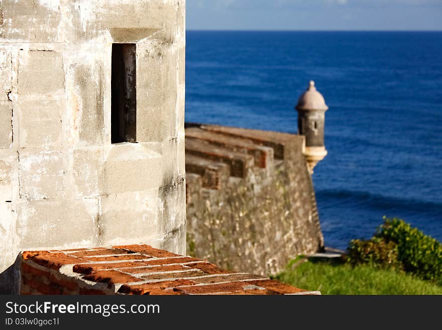 A beautiful close up view of an observation window in a guerite, or sentry box, with another guerite and the Caribbean Sea in the distance along the coastal side of Fort San Cristobal in Old San Juan, Puerto Rico. Also known as Castillo de San Cristóbal, it was the largest fort ever built by the Spanish in the New World, designed to help protect San Juan from land based attacks. A beautiful close up view of an observation window in a guerite, or sentry box, with another guerite and the Caribbean Sea in the distance along the coastal side of Fort San Cristobal in Old San Juan, Puerto Rico. Also known as Castillo de San Cristóbal, it was the largest fort ever built by the Spanish in the New World, designed to help protect San Juan from land based attacks.