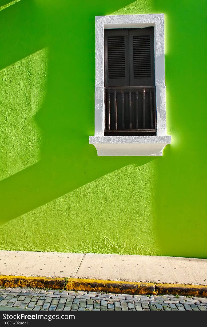 Rich medium brown shutters set against an electric green wall wall provide a beautiful view of Old San Juan Caribbean architecture in Old San Juan, Puerto Rico. Colorful architecture and blue cobble stone streets are part of the charm of Old San Juan. Rich medium brown shutters set against an electric green wall wall provide a beautiful view of Old San Juan Caribbean architecture in Old San Juan, Puerto Rico. Colorful architecture and blue cobble stone streets are part of the charm of Old San Juan.