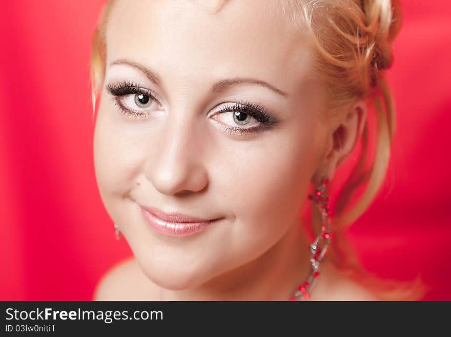 Portrait of the girl with a smile on a red background