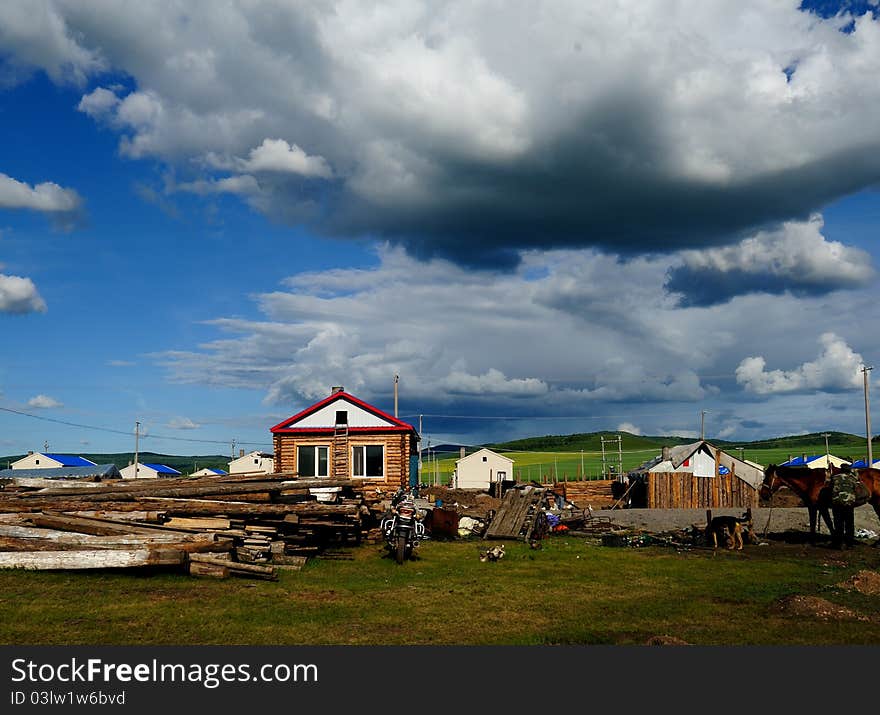 Log Cabin under blue sky and white clouds.