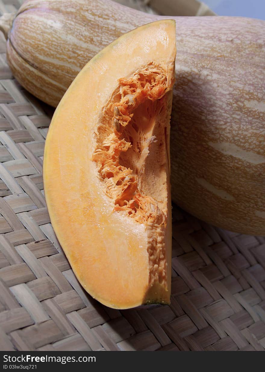 This is a be cut into slices, the mature, but not processed pumpkin, background is a whole pumpkins.