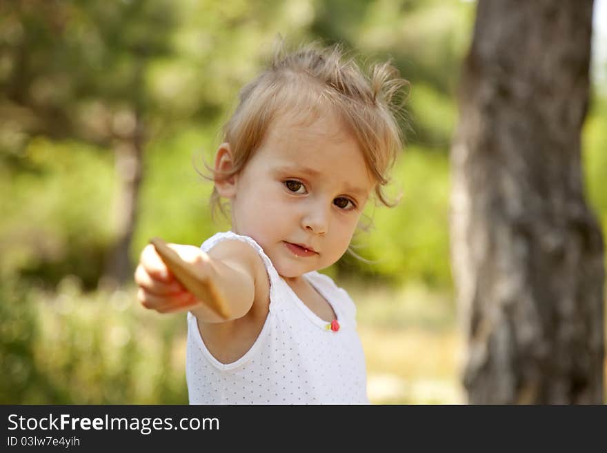 Little girl show you a cracker in the park.