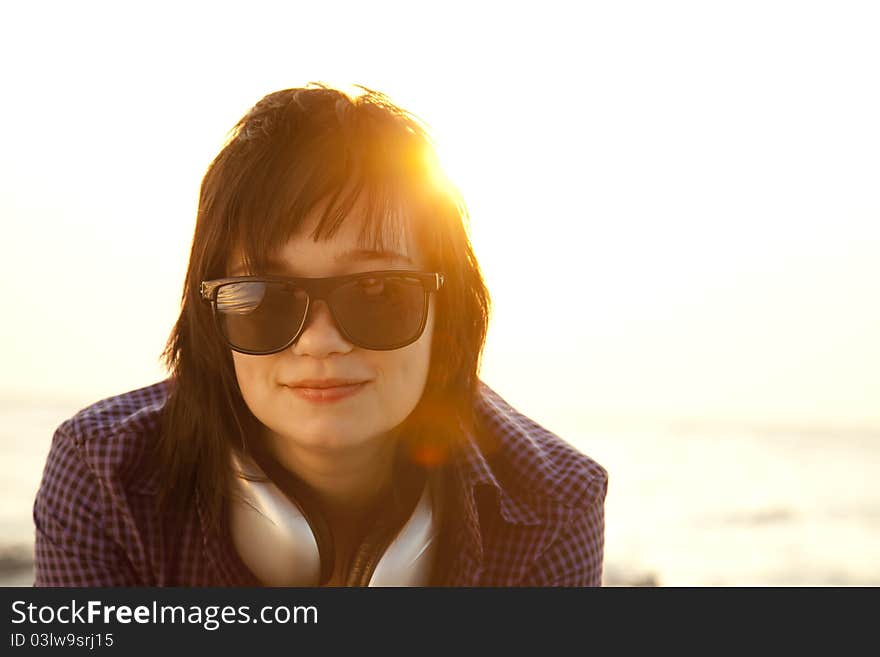 Beautiful brunette girl with headphones at beach sand in sunrise time. Beautiful brunette girl with headphones at beach sand in sunrise time.