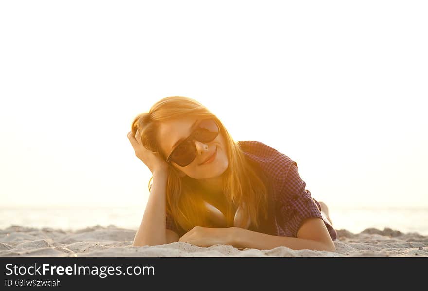 Girl with headphones at beach sand.