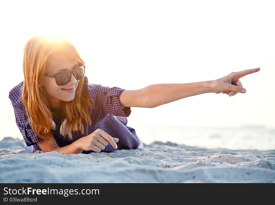 Girl with headphones at beach sand.