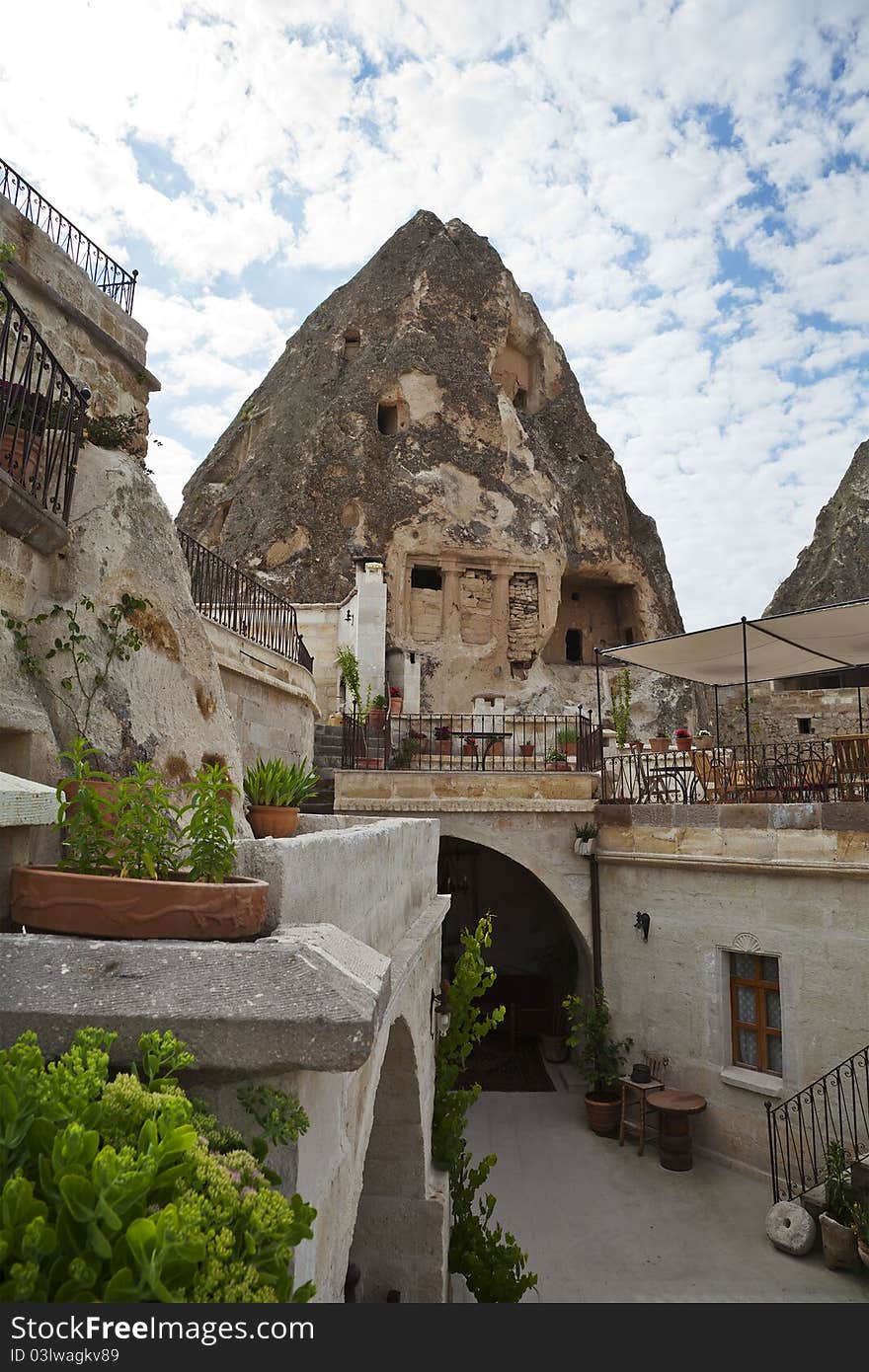 Turkish villa, built into caves, with verandas, canopies, awnings under a cloudy sky. portrait with copy space. Turkish villa, built into caves, with verandas, canopies, awnings under a cloudy sky. portrait with copy space