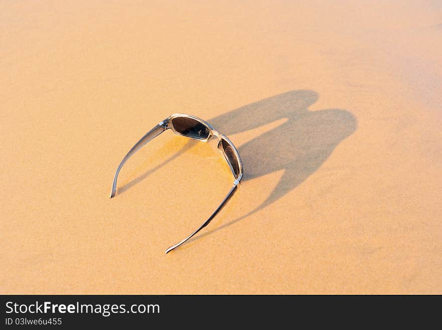 Sun glasses on the sandy sea shore