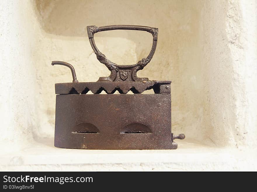 Limestone alcove with cast iron clothes iron on a ledge, horizontal copy space. Limestone alcove with cast iron clothes iron on a ledge, horizontal copy space