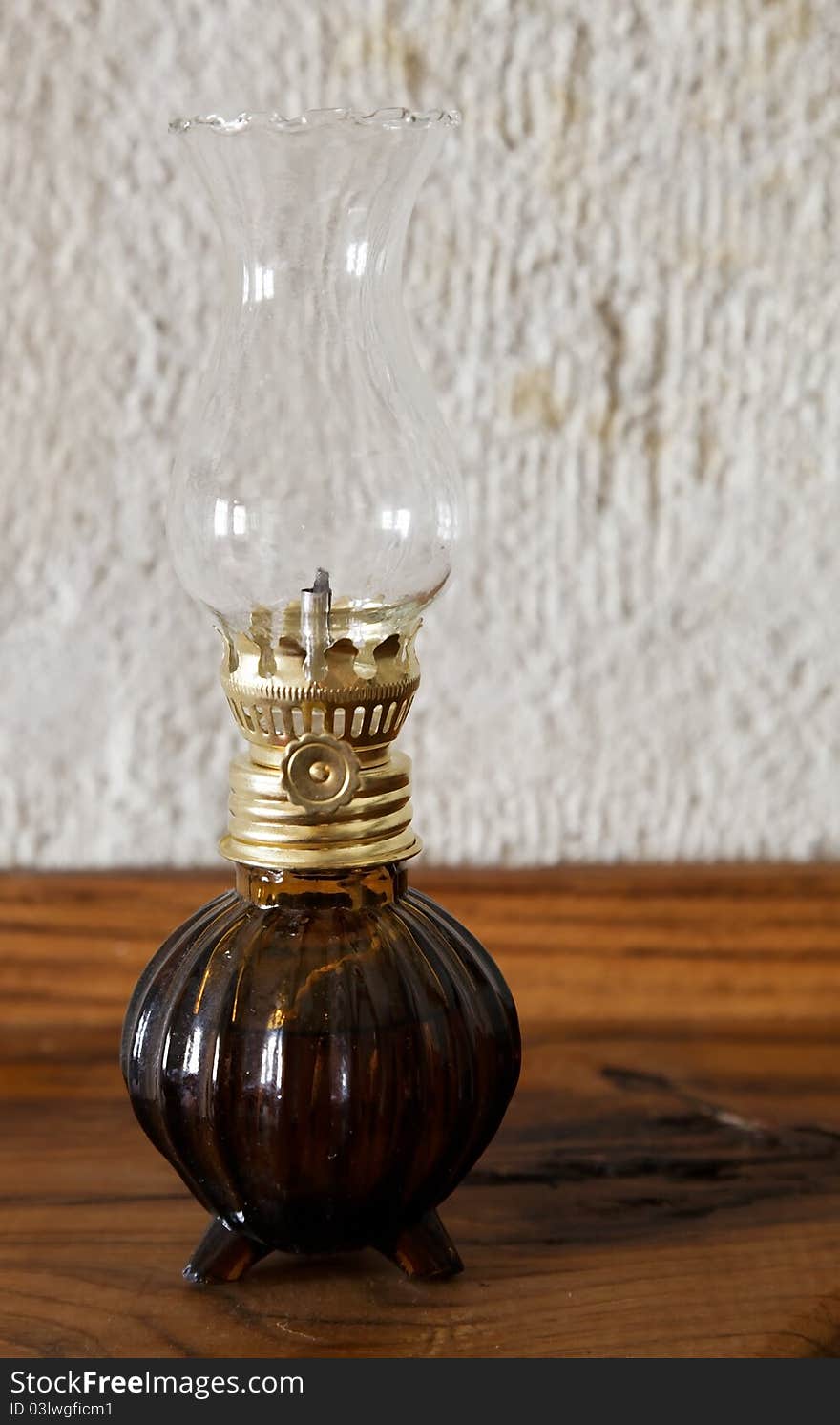 Ornamental oil lantern on a side board with limestone background. Ornamental oil lantern on a side board with limestone background