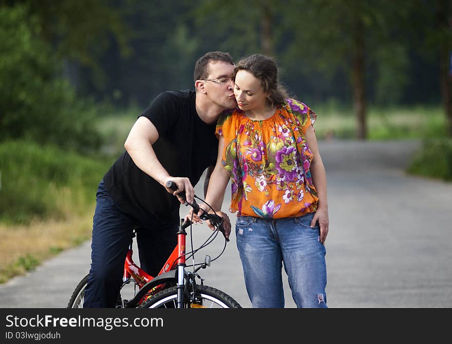 Happy couple in park with red bicycle. Happy couple in park with red bicycle