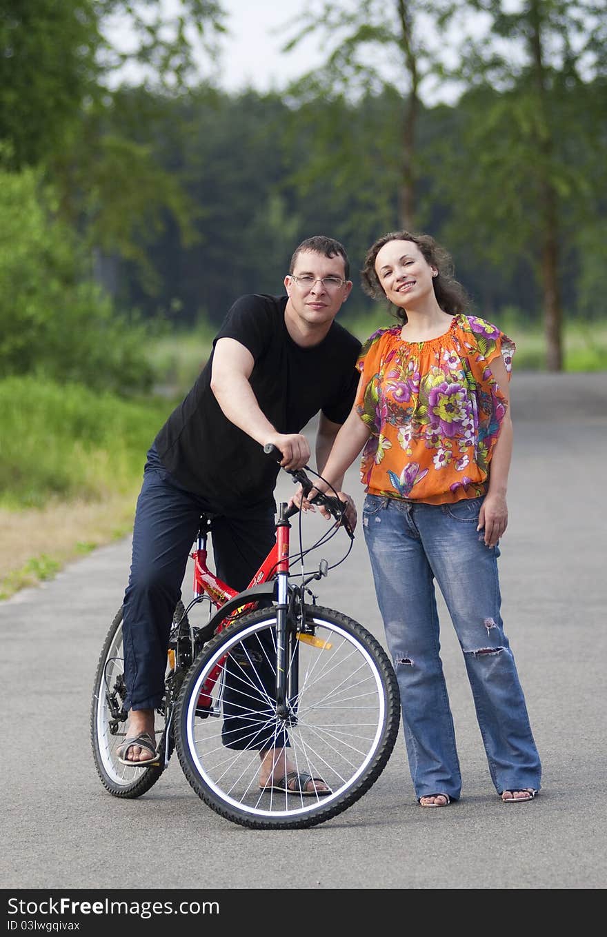 Happy couple in park with red bicycle. Happy couple in park with red bicycle