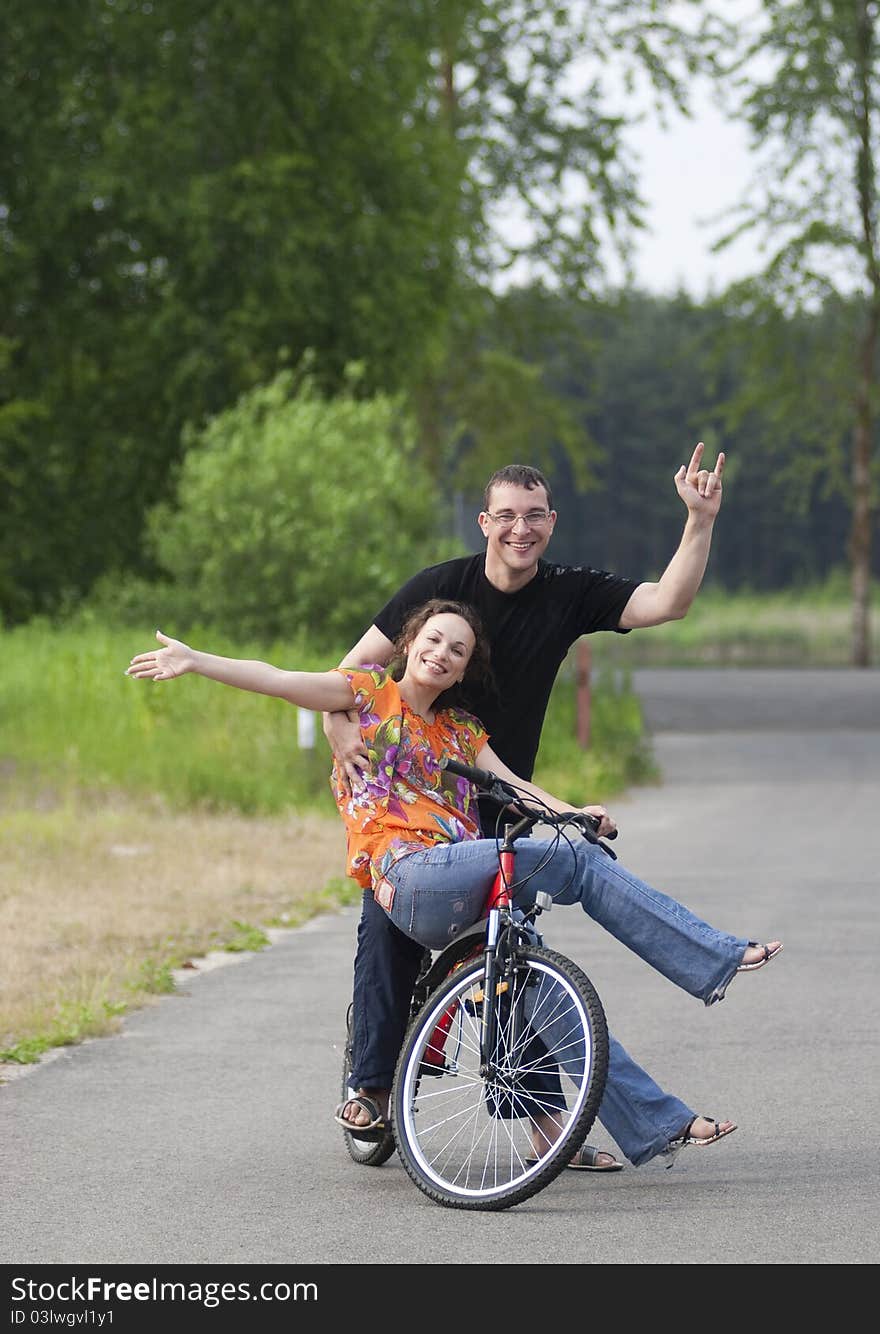 Happy couple sitting together at one bicycle. Happy couple sitting together at one bicycle