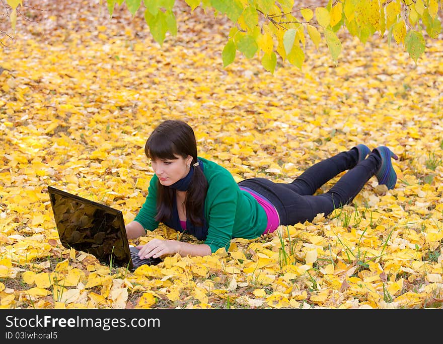 Young Girl With A Laptop In A Autumn Foliage