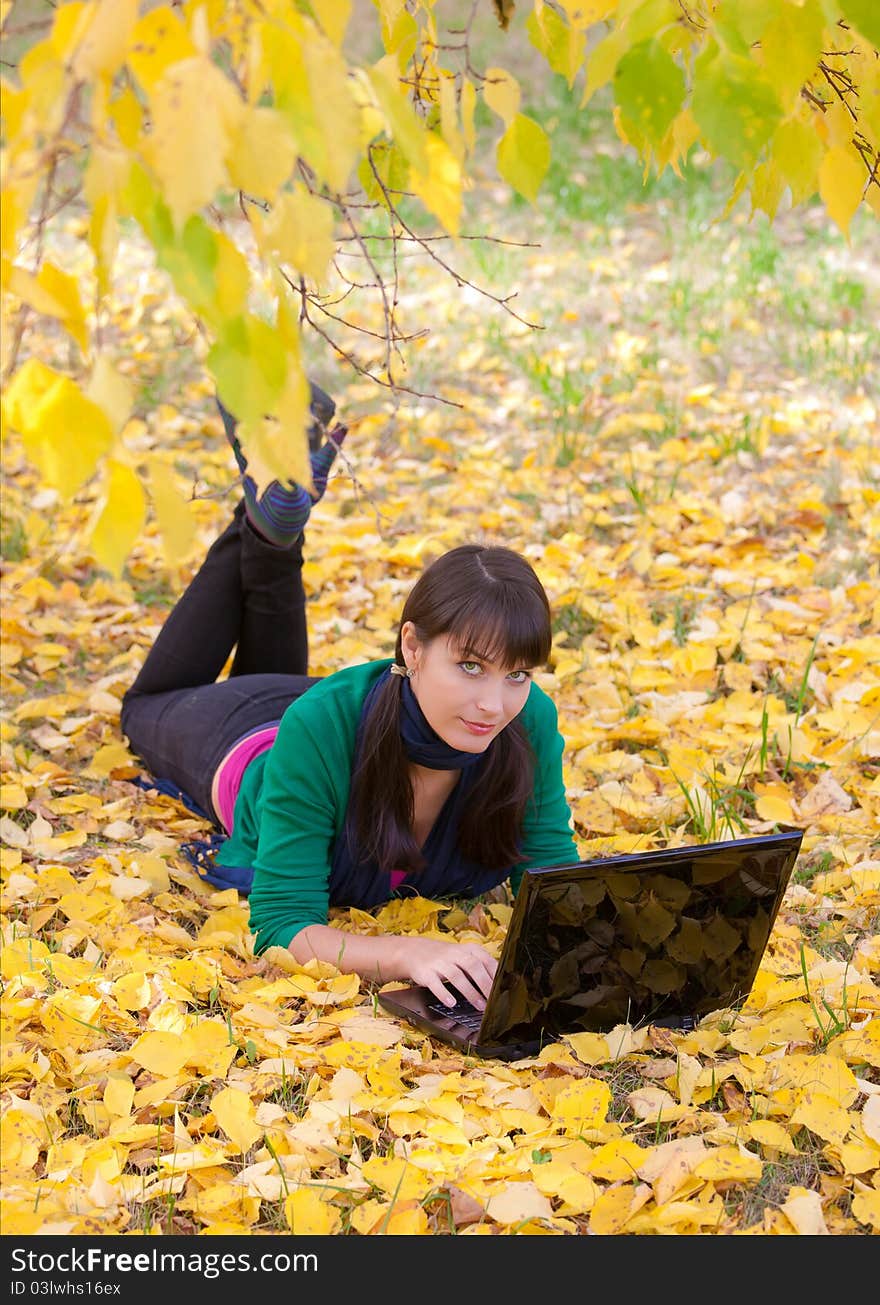 Young Girl With A Laptop In A Autumn Foliage