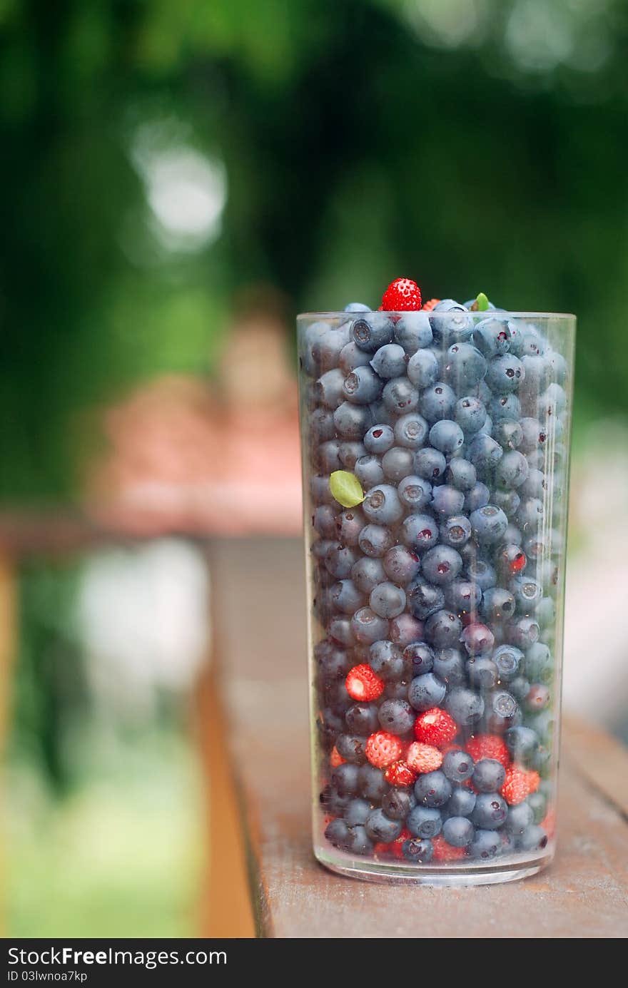 Colourful berries in the plastic glass on the balcony. Shallow dof. Colourful berries in the plastic glass on the balcony. Shallow dof