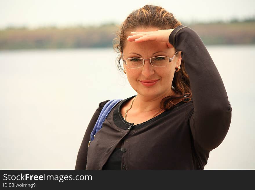 This photograph shows a beautiful young woman near a river. This photograph shows a beautiful young woman near a river.