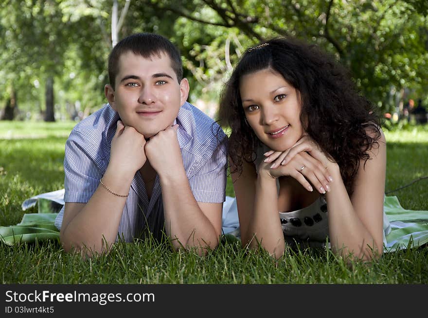 Couple lays together on a grass