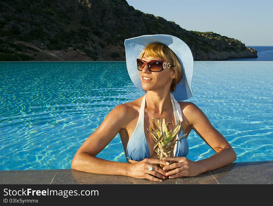 Beautiful woman in the swimming pool near coast