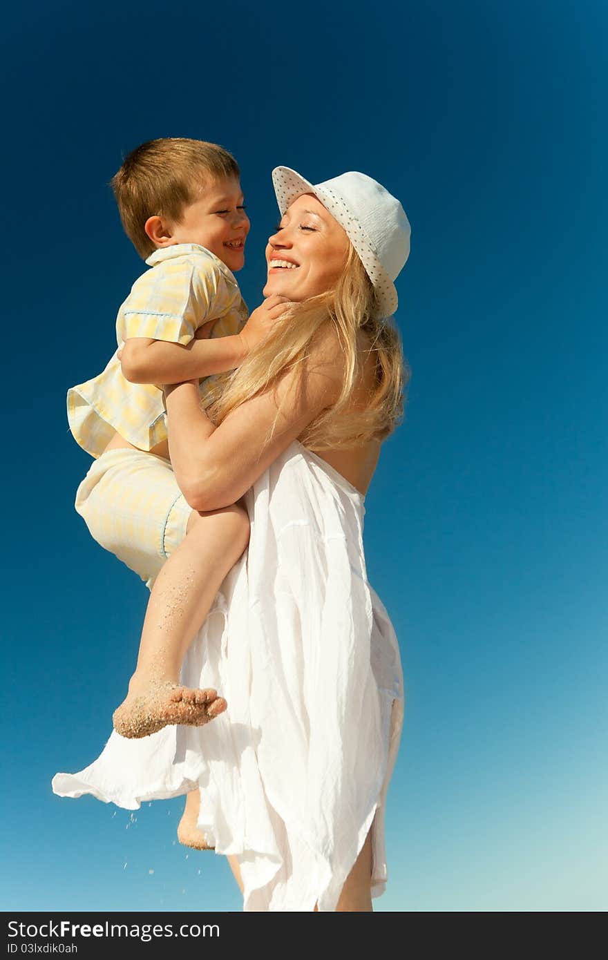 Boy flying on his mother's hands at beach