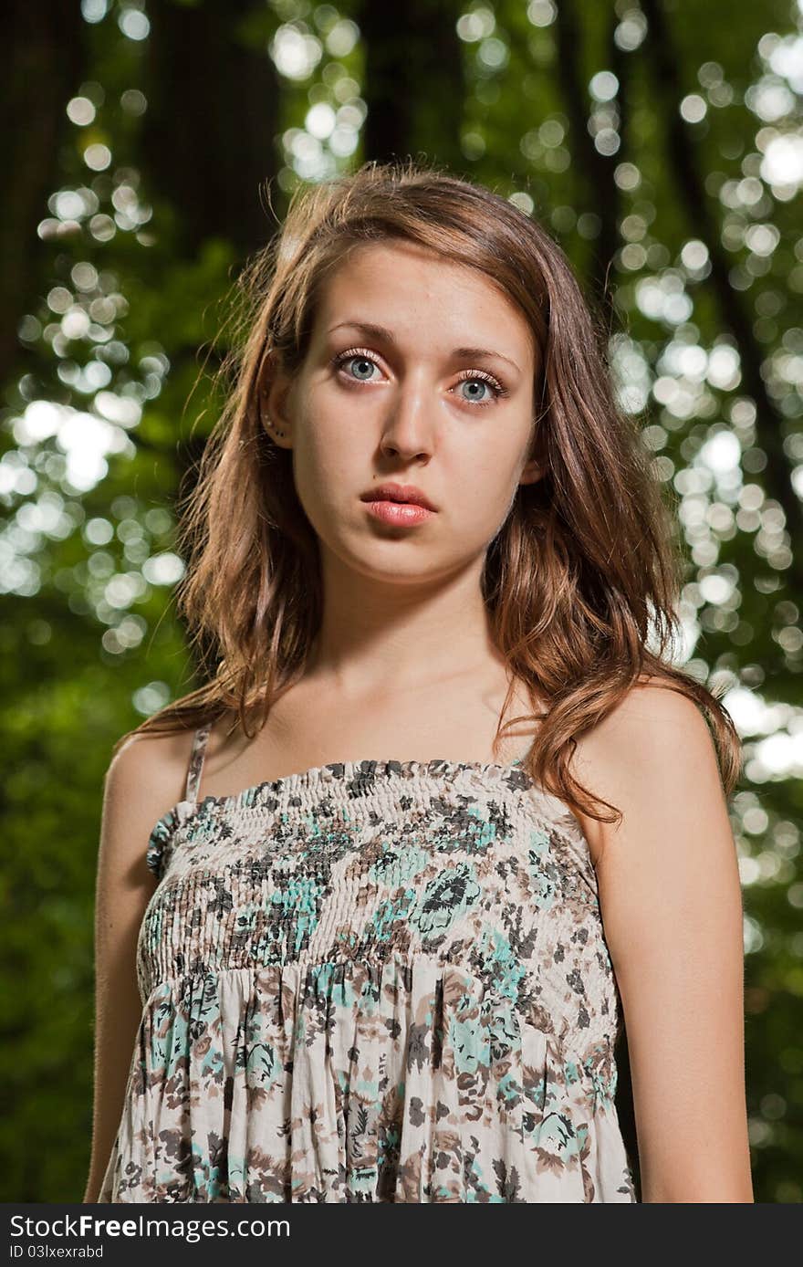 Portrait of attractive teen on green trees background