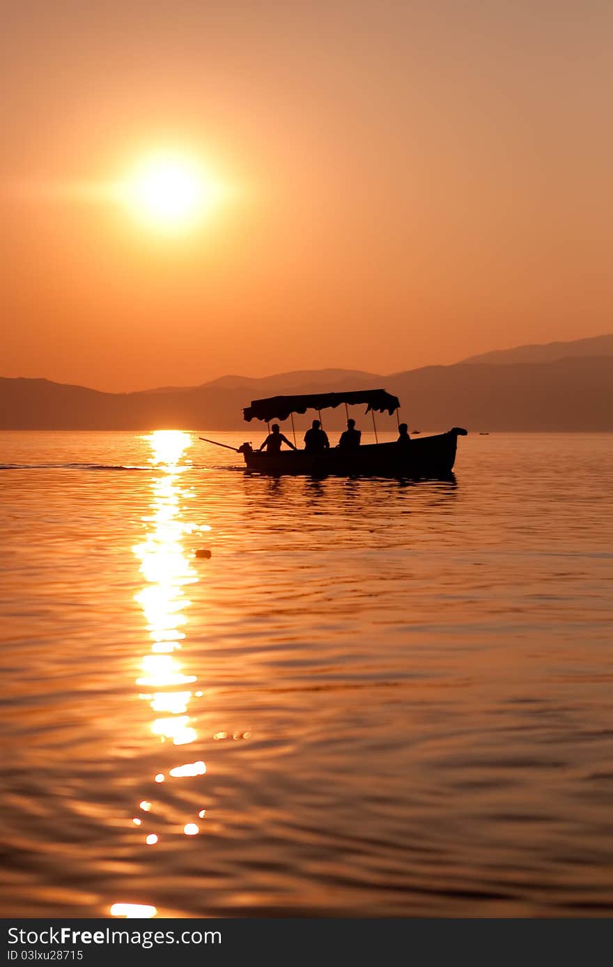 Summer sunset over lake with small boat. Summer sunset over lake with small boat