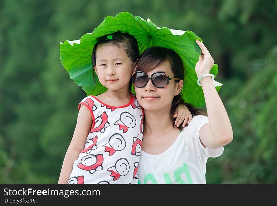 Chinese girl and mum with lotus leaf hat