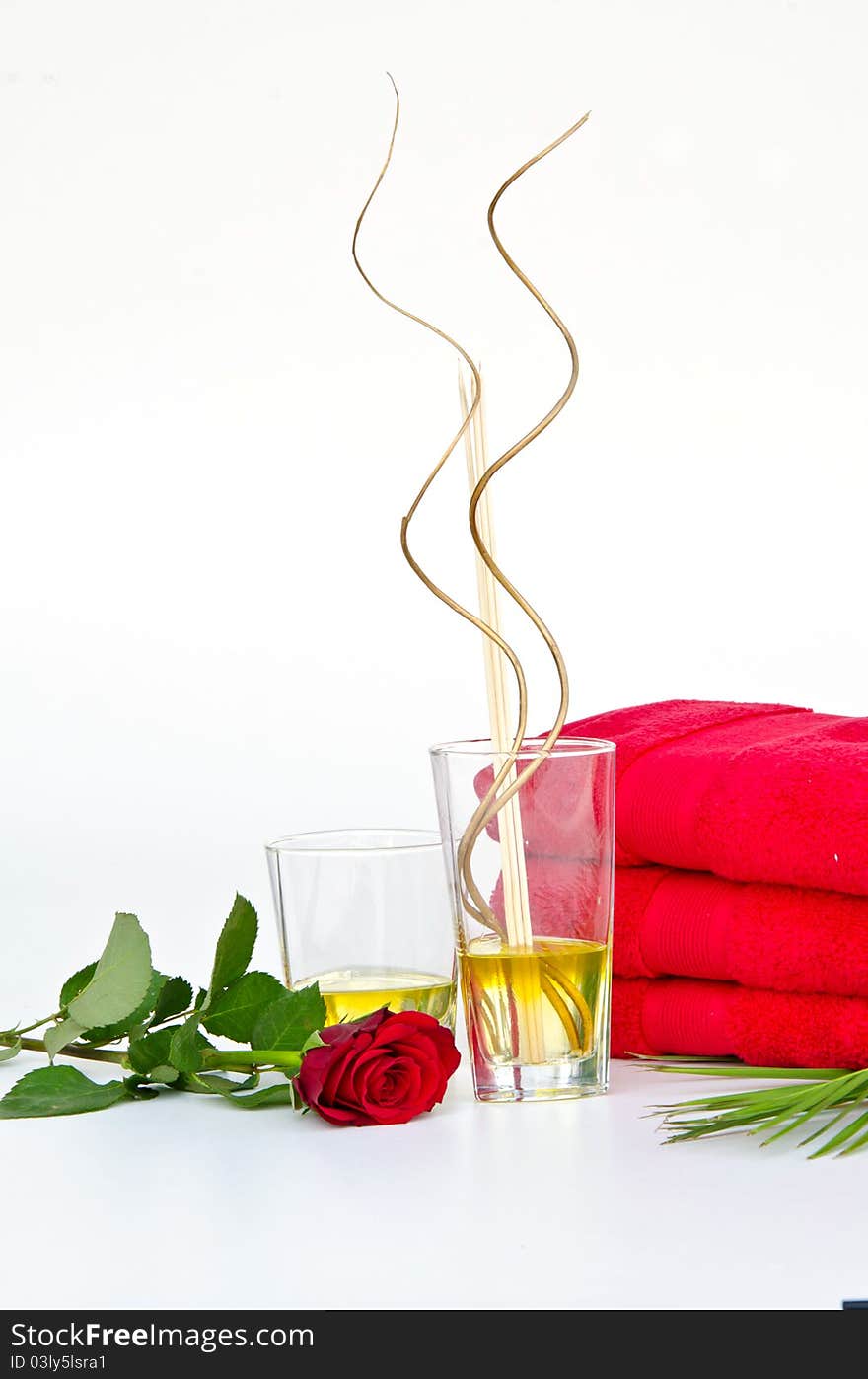 SPA Background of red towels and red rose with Massage Oil Glasses