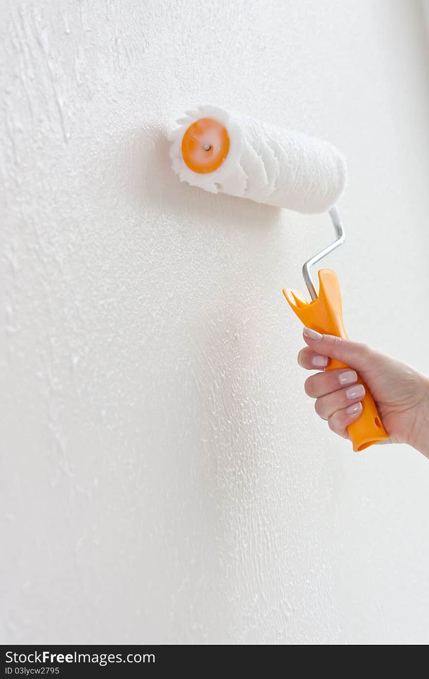 Putting glue on th a white wall with a paint roller. Putting glue on th a white wall with a paint roller