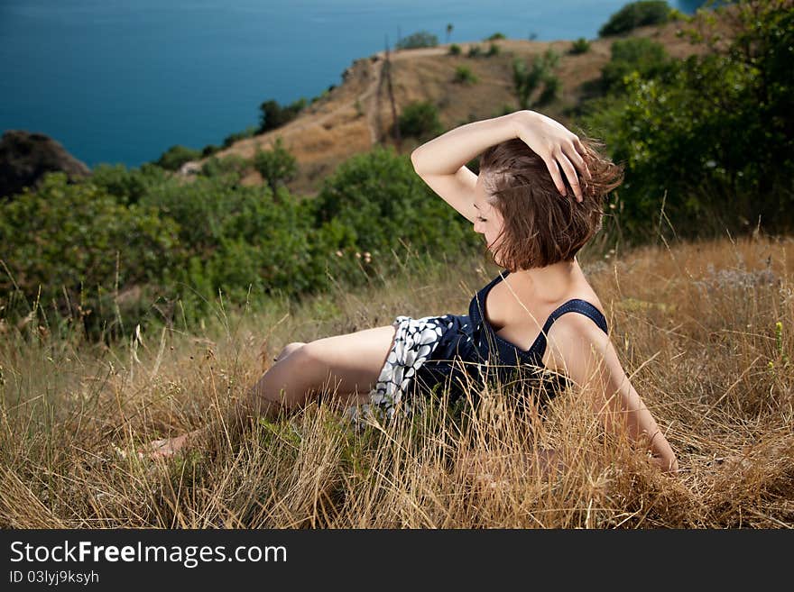 Outdoor shot of the young beautiful smiling woman laying on the grass. Outdoor shot of the young beautiful smiling woman laying on the grass