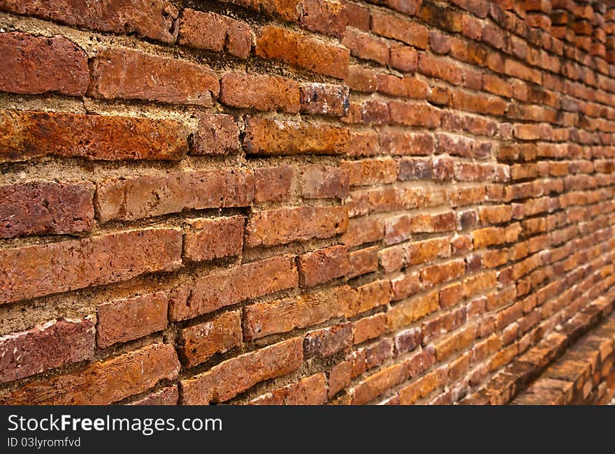 Ruin laterite brick wall texture tilted out close up. Ruin laterite brick wall texture tilted out close up