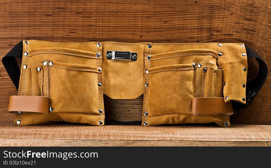 One empty suede  carpenter belt on wooden boards. One empty suede  carpenter belt on wooden boards