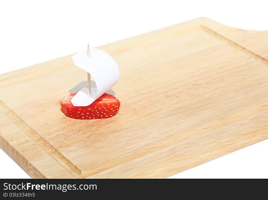 Boat, made of fresh strawberries on a kitchen hardboard