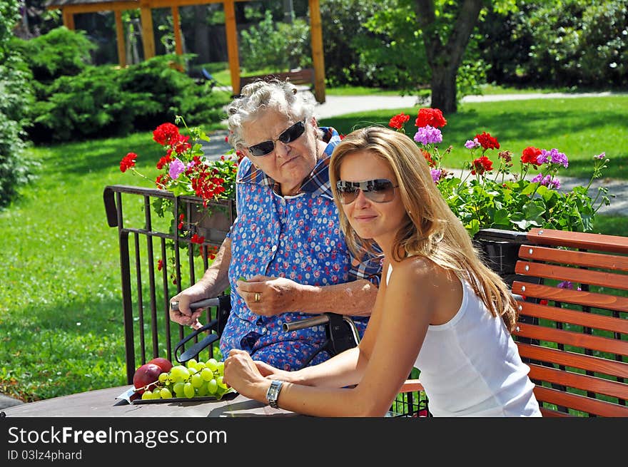 Portrait of grandmother and granddaughter taken in the exterior.