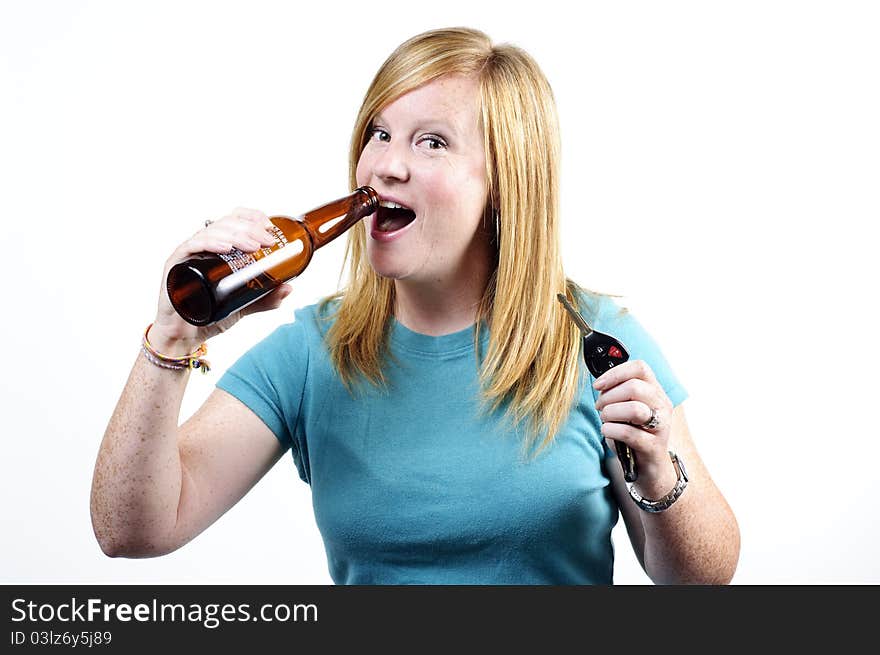 A woman drinking a beer while she holds a car key and beer bottle in her hands. A woman drinking a beer while she holds a car key and beer bottle in her hands.