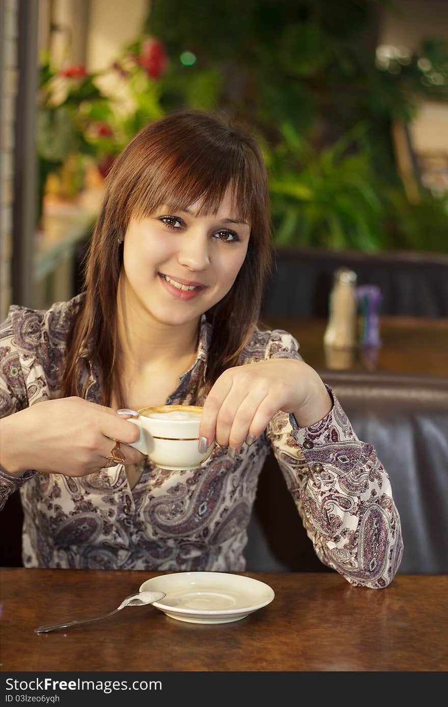 Beautiful girl with brown eyes, resting in a cafe