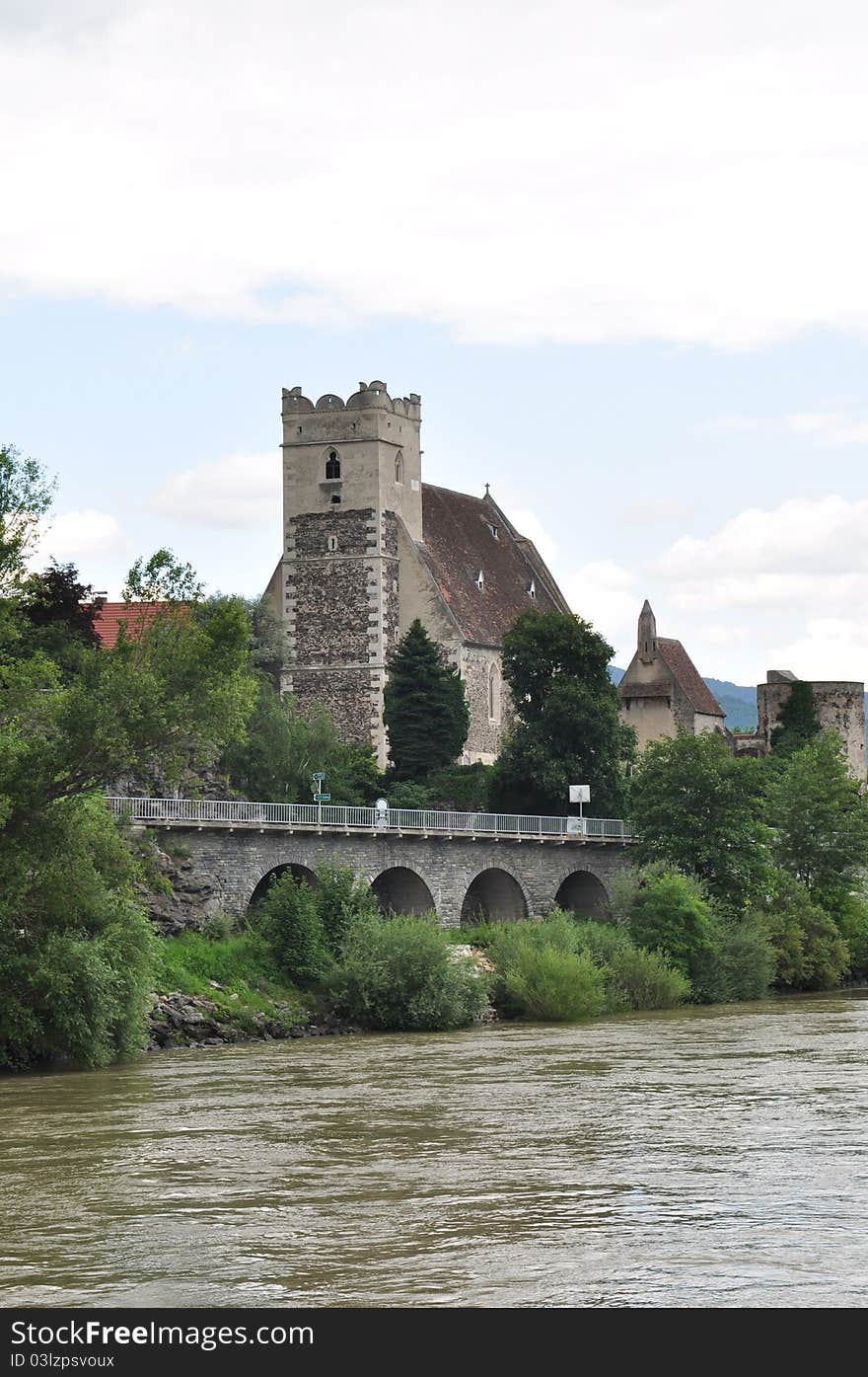 Medieval castle next to a running river access by bridge. Medieval castle next to a running river access by bridge